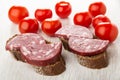 Tomato, sandwiches with smoked sausage on wooden table Royalty Free Stock Photo