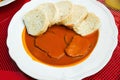 Tomato sauce, beef and dumpling on white plate