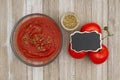 Tomato sauce in clear bowl with oregano spice and red vine ripe tomatoes on weathered wood background Royalty Free Stock Photo