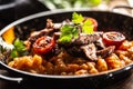 Tomato sauce gnocchi with sous-vide beef and fresh tomatoes served in a dark plate Royalty Free Stock Photo