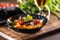 Tomato sauce gnocchi with sous-vide beef and fresh tomatoes served in a dark plate Royalty Free Stock Photo