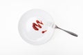 Tomato sauce, ketchup on white ceramic plate with a fork isolated on white, tasty dinner or lunch is over, concept of