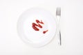 Tomato sauce, ketchup on white ceramic plate with a fork isolated on white, tasty dinner or lunch is over, concept of slimming