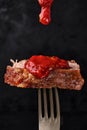 Tomato sauce pouring above juisy piece of grilled meat Royalty Free Stock Photo