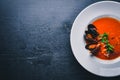 Tomato and seafood creamy soup with mussels. On a wooden background. Top view.