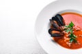 Tomato and seafood creamy soup with mussels.