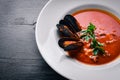 Tomato and seafood creamy soup with mussels.