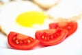 Tomato slice in the fried eggs close Royalty Free Stock Photo