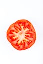 Tomato slice isolated on white background. Fresh tomato. Top view, flat lay. Royalty Free Stock Photo