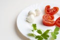 Tomato slices, mozzarella balls and sprigs of parsley