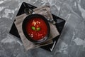 Tomato soup in a black bowl on a gray stone background. View from above. Copy space. Gray background. calm light. Food Royalty Free Stock Photo