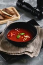 Tomato soup in a black bowl on a gray stone background. View from above. Copy space. Gray background. calm light. Food Royalty Free Stock Photo