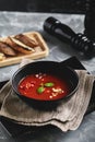 Tomato soup in a black bowl on a gray stone background. View from above. Copy space. Gray background. calm light. Food Royalty Free Stock Photo