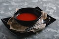 Tomato soup in a black bowl on a gray stone background. View from above. Copy space. Gray background. calm light. Food Royalty Free Stock Photo