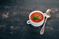 Tomato soup with chili and vegetables. Healthy food. On a black wooden background.