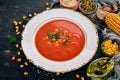 Tomato soup with chili and vegetables. Healthy food. On a black wooden background