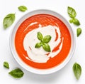 Tomato soup puree in a bowl with cream and fresh basil leaves, isolated on white background. Top view Royalty Free Stock Photo