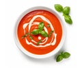 Tomato soup puree in a bowl with cream and fresh basil leaves, isolated on white background. Top view Royalty Free Stock Photo