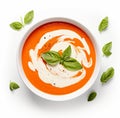 Tomato soup puree in a bowl with cream and fresh basil leaves, isolated on white background. Top view Royalty Free Stock Photo