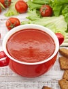 Tomato soup in red ceramic bowl on rustic wooden background. Hea Royalty Free Stock Photo