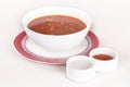 Tomato soup,  served with sour cream and extra tomato sauce,  white and red plate,  light background,  isolated Royalty Free Stock Photo