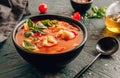 Tomato soup with tortellini in black bowl on dark background