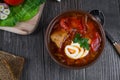 Tomato soup . Traditional Ukrainian beetroot and tomato soup - borsch in clay pot with sour cream, herbs and bread