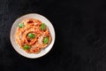 Tomato spaghetti. Pasta with red sauce, grated Parmesan cheese and fresh basil, shot from the top on a dark background Royalty Free Stock Photo