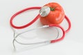 Tomato and stethoscope. Healthy food concept