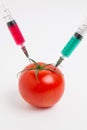 Tomato and syringe with nitrates. GMO food ingredient concept