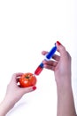Tomato with syringe