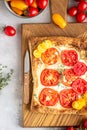 Tomato tart, puff pastry topped with cream cheese or ricotta and tomatoes. Royalty Free Stock Photo