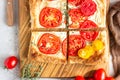 Tomato tart, puff pastry topped with cream cheese or ricotta and tomatoes. Royalty Free Stock Photo