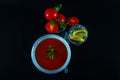 Tomato vegetarian soup with metal tin, fresh tomatoes, water wit Royalty Free Stock Photo