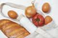 Tomato, white bread, white bottle, onion, eggs in tote bag on white background close textured