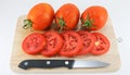 Tomato on wood chopping block with knife white background isolated Royalty Free Stock Photo