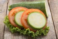 Tomato and zuchini slice on wood background. Royalty Free Stock Photo