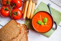 Tomatoe soup with bread sticks and basil on wooden background Royalty Free Stock Photo