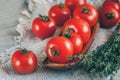 Tomatoes on a beautiful old metal plate with a thyme with a knife and scissors on a wooden table in a rustic style. Royalty Free Stock Photo