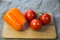 Tomatoes, bell pepper lying on a wooden Board Royalty Free Stock Photo