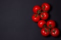 Tomatoes on a black background. Tomatoes on a vine on a dark background.