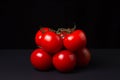Tomatoes on a black background. Tomatoes on a vine on a dark background.