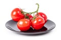 Tomatoes on a branch on a black plate Royalty Free Stock Photo