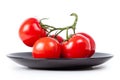 Tomatoes on a branch on a black plate Royalty Free Stock Photo