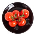 Tomatoes on a branch on a black plate Royalty Free Stock Photo