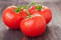 Tomatoes branch on a black wooden table with water droplets Royalty Free Stock Photo