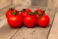 Tomatoes branch on a black wooden table with water droplets Royalty Free Stock Photo