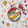 Tomatoes on a branch of thyme herb seasoning lemon cucumbers and tomatoes carrots in a pan with vegetables laid out around on wood Royalty Free Stock Photo