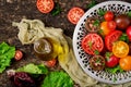 Tomatoes of different colors with green herbs Royalty Free Stock Photo