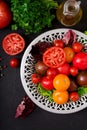 Tomatoes of different colors with green herbs Royalty Free Stock Photo